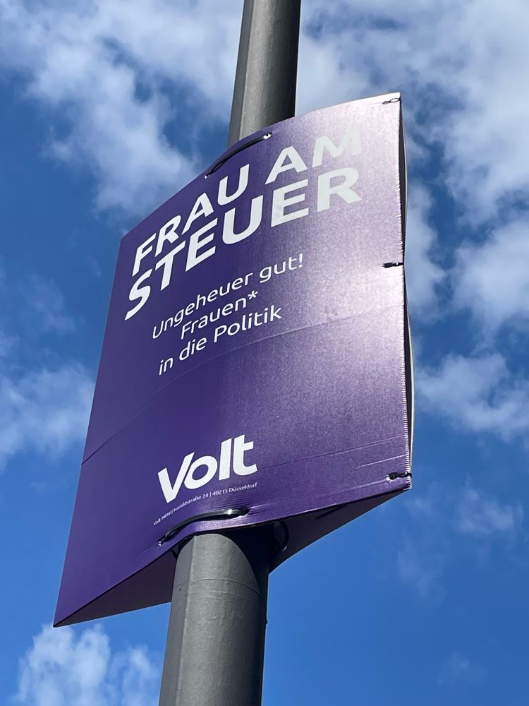 Ein Wahlplakat von Volt: „Frau am Steuer“ steht ganz oben, dann folgt in kleinerer Schrift „ungeheuer gut! Frauen in die Politik“