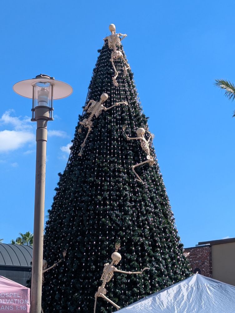 Skeletons climbing a Christmas tree, blooming and reaching out of the Christmas tree just like the small creatures bursting out of Shin Godzilla's corpse at the end of the film