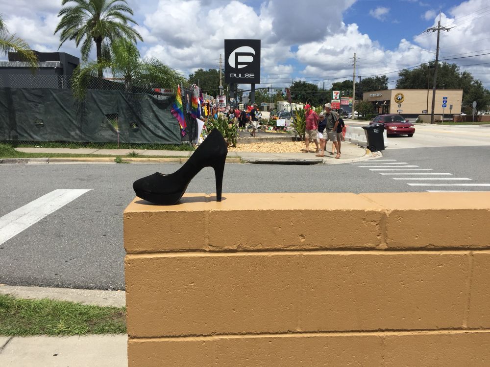 An abandoned high-heel shoe on a low cinderblock wall at the Dunkin across from Pulse in the weeks after the shooting, before the crosswalk was painted to honor the victims.