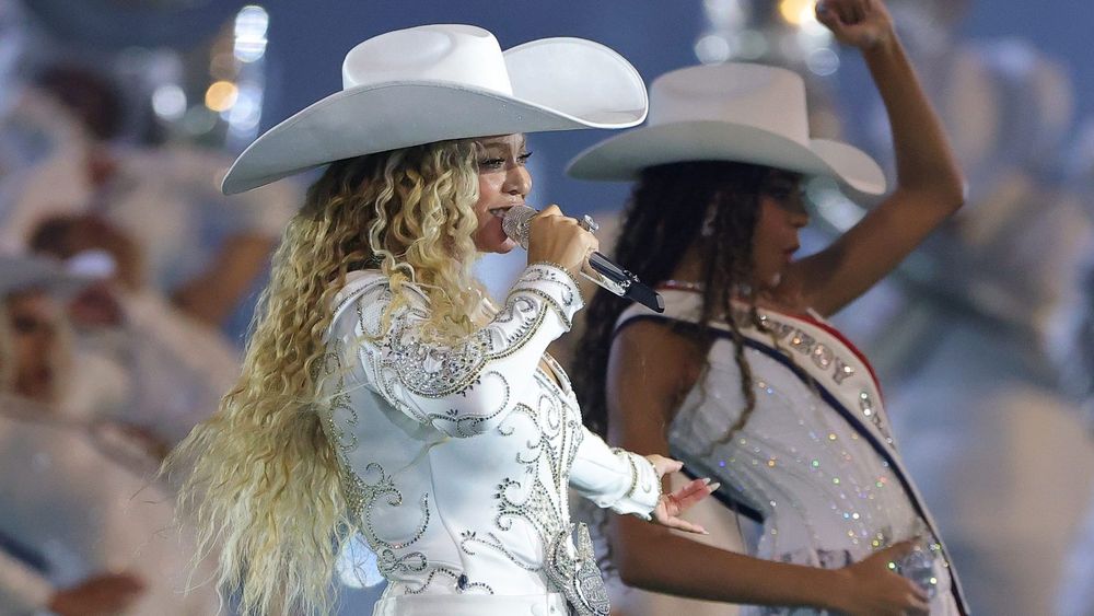 Beyoncé performing in a white cowboy outfit with her daughter Blue Ivy
