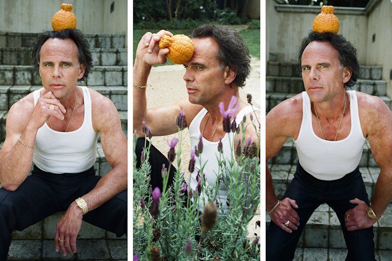 Walton Goggins posing in a tank top with some kind of lil vegetable on his head. He's quite silly and cute and whimsical about it