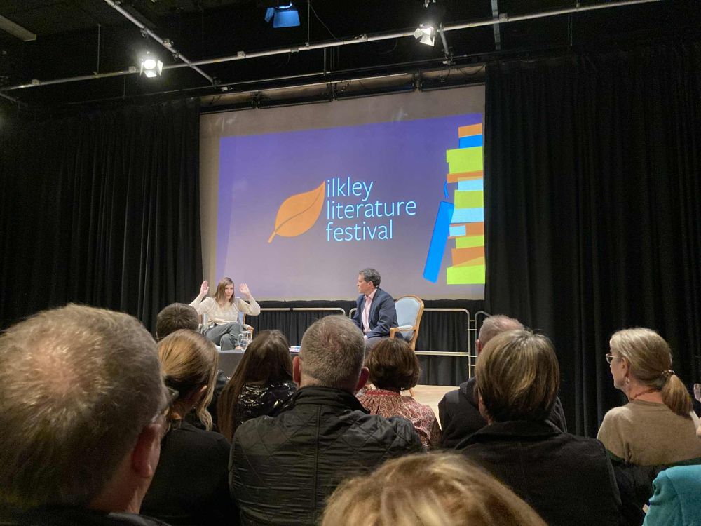 Me on stage at Ilkley Literature festival making a big hand gesture for no good reason