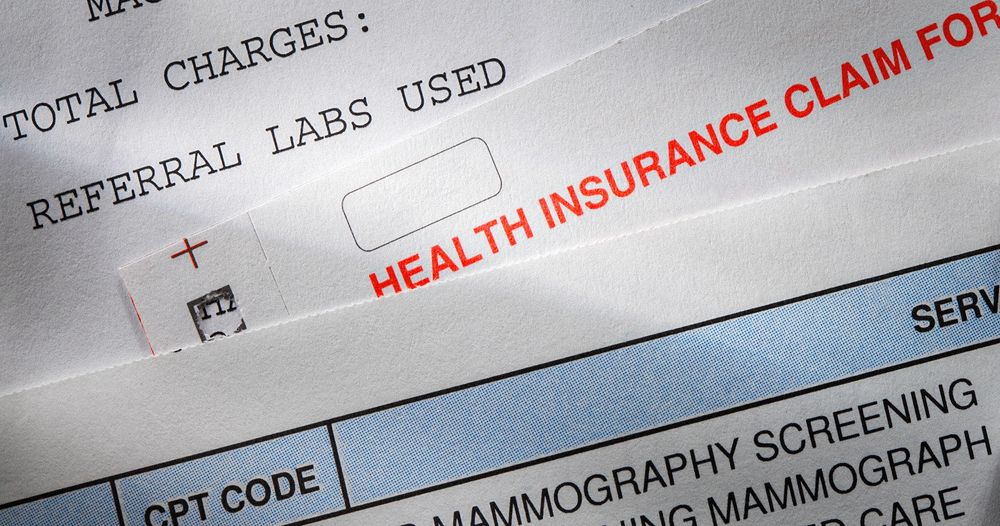 a close up shot of stress-inducing health insurance claim forms and receipts