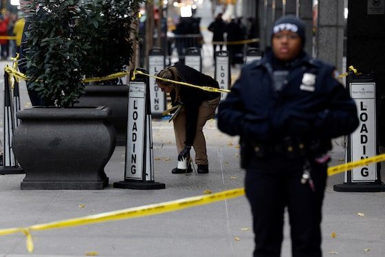 A member of the NYPD Crime Scene Unit works near evidence markers placed where shell casings were found at the scene where the CEO of UnitedHealthcare Brian Thompson was shot and killed in Midtown Manhattan, in New York, on Dec. 4.