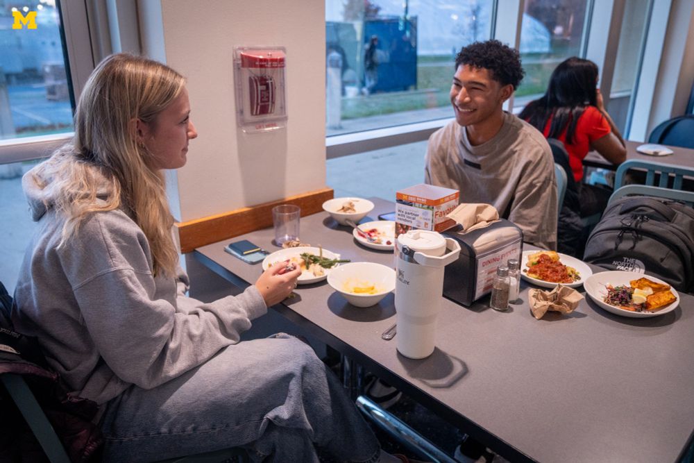 Two U-M students eating at Michigan Dining’s Thanksgiving Dinner.