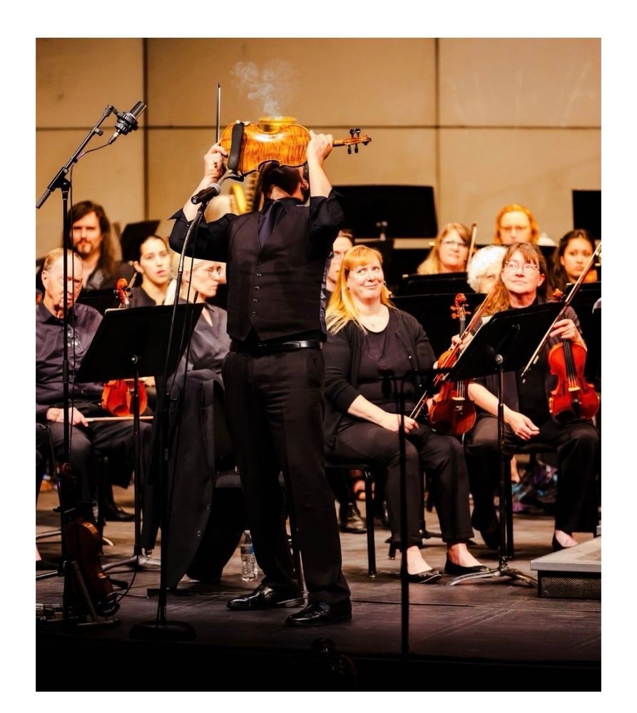 a man, blowing the rosin dust from the strings in the middle of the Devil going down to Georgia, while the rest of the orchestra side-eyes him