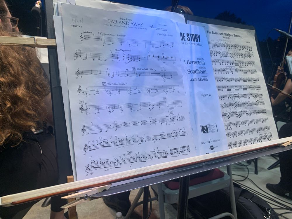 photograph of a music stand on stage with parts for a pops concert
