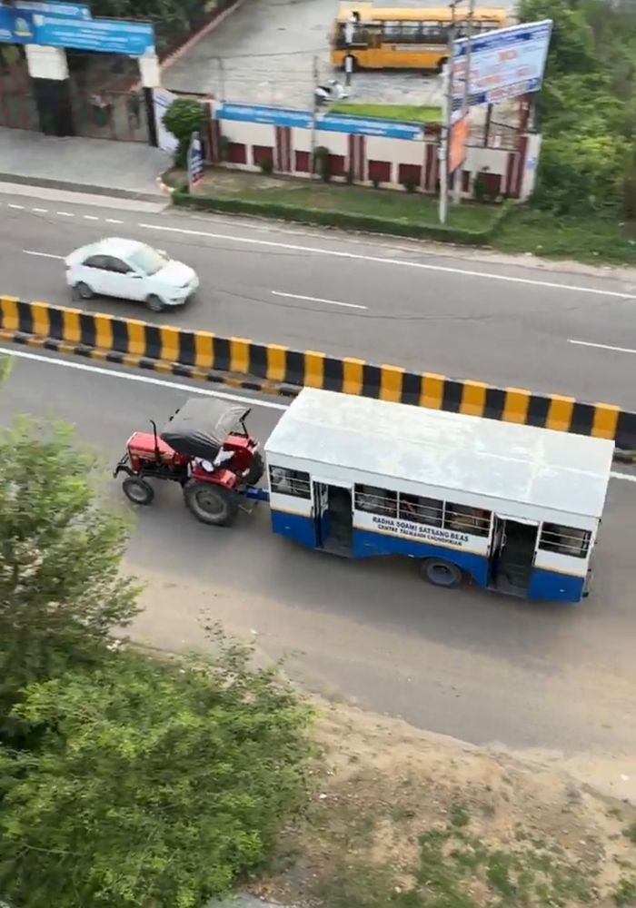 A tractor pulling a converted bus without engine 