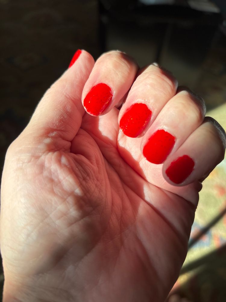 My hand with bright red fingernails 