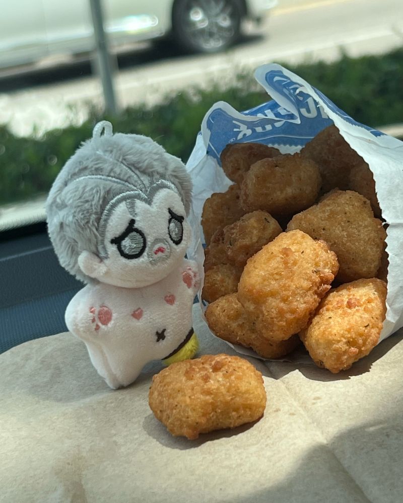 Teeny Izzy looks distressingly at a giant pile of cheese curds. 