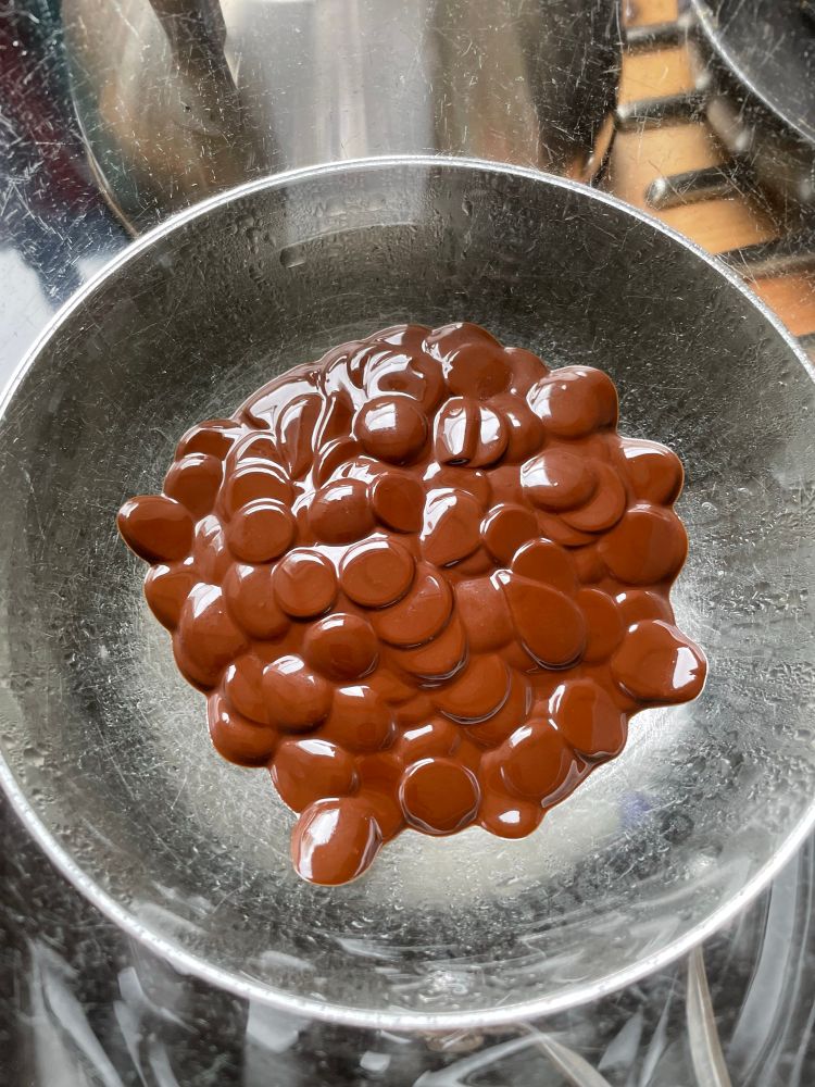 Chocolate buttons melting in a glass bowl 