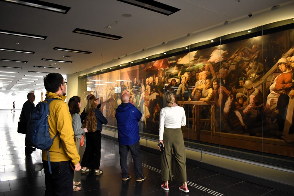 A group of people looking at a painting