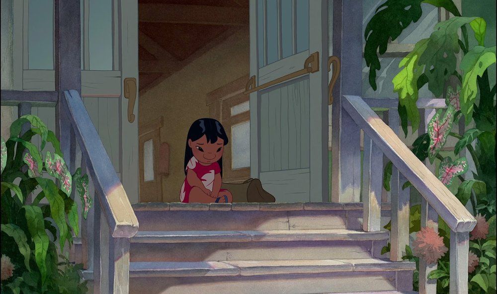 still from 2002 "Lilo & Stitch" showing Lilo sitting sadly on a porch