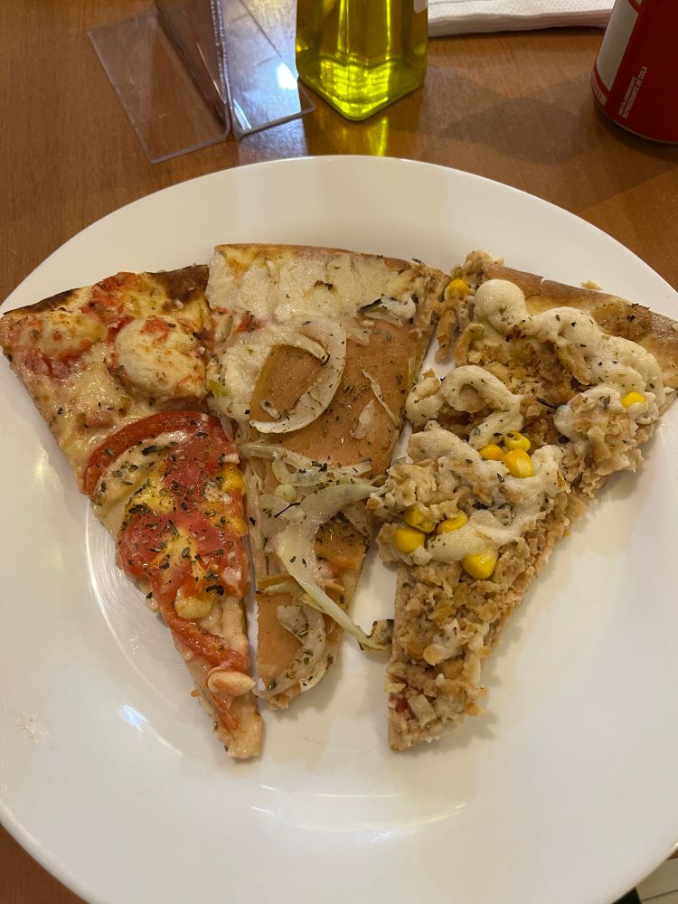 três pedaços de pizza vegana em um prato branco 