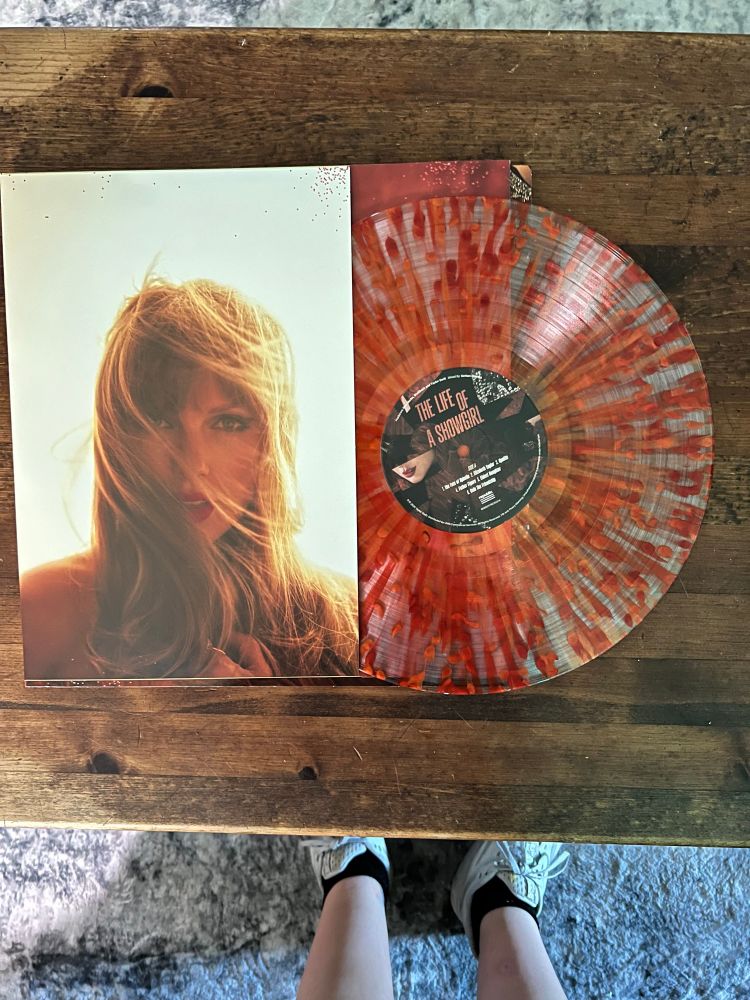 The insert for the vinyl showing Taylor on the left from the big photo on the showgirl wall, the lover-esque hair in the face cameo style image. On the right is the stunning red and orange mottled vinyl 