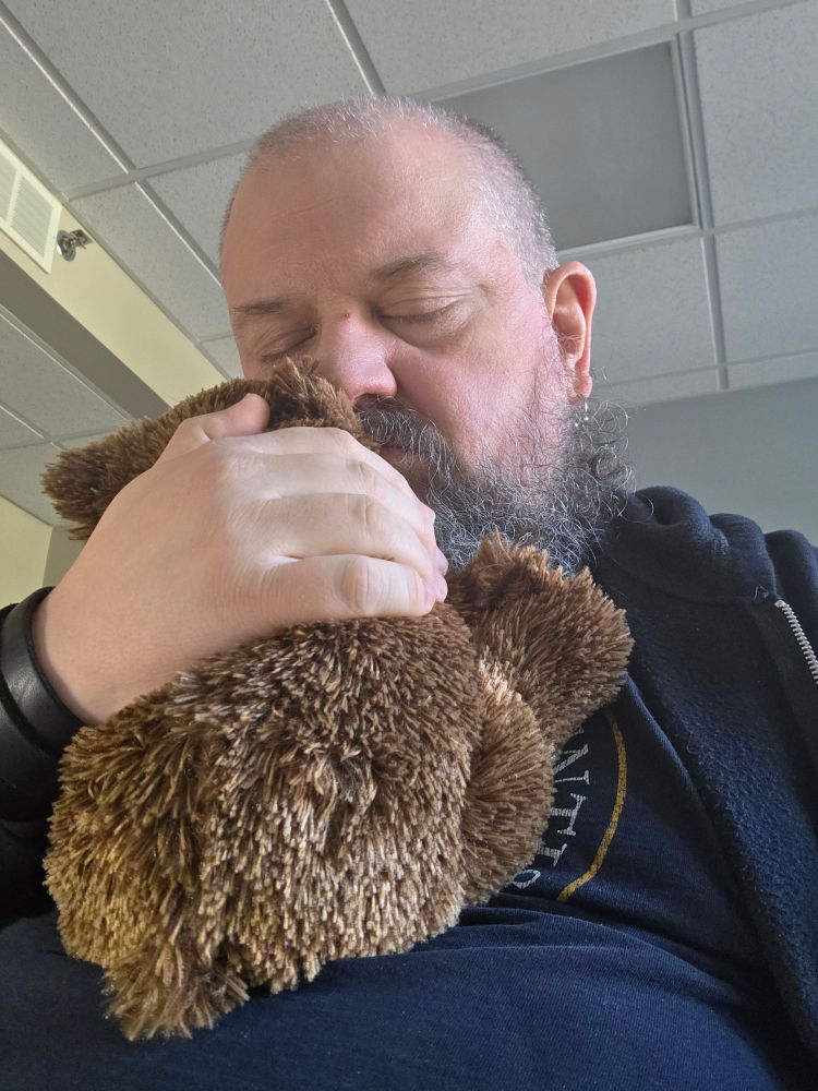 Me hugging a teddy bear at work to stay sane