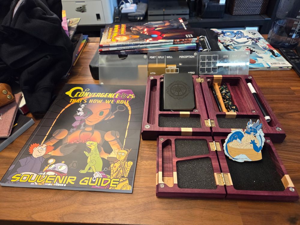 Dice boxes next to the CONvergence souvenir guide