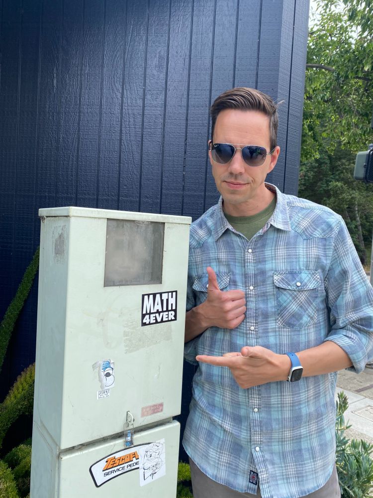 me, next to a power box with a "Math 4ever" sticker on it.