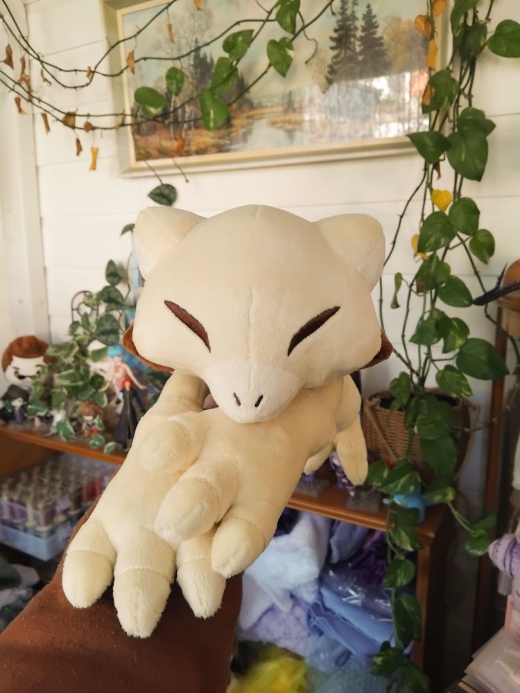 A handmade plush of the pokemon abra, in shiny colours