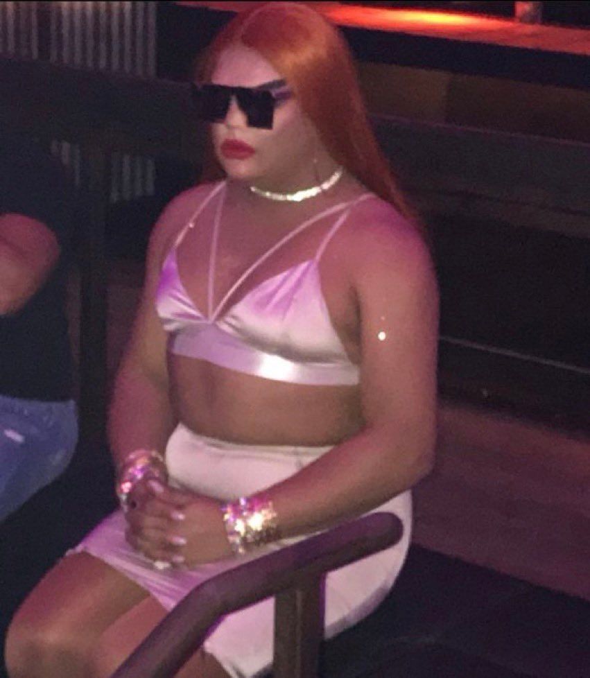 A woman sitting alone in a club looking very unamused 
