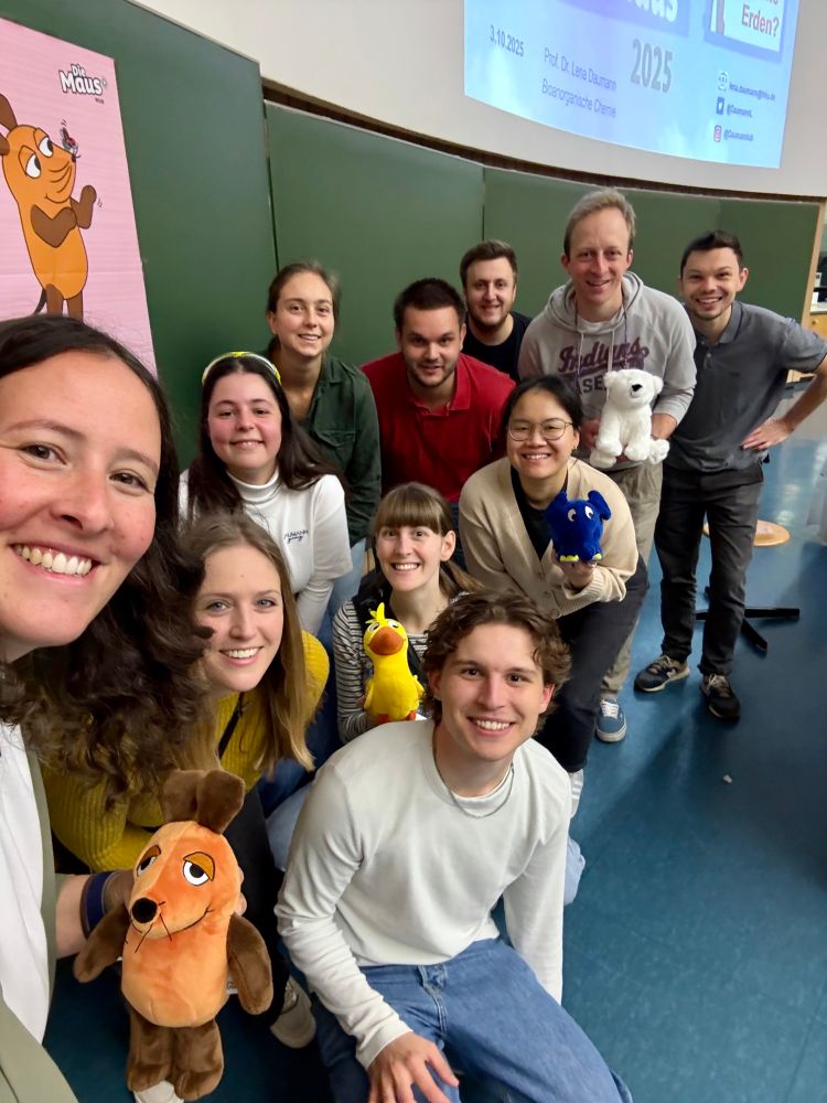 The team behind Türen auf mit der Maus. 11 people smiling for a selfie, plush animals are shown into the camera 