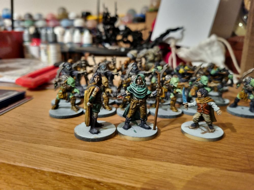 Some painted lord of the rings figures  on a wooden desk