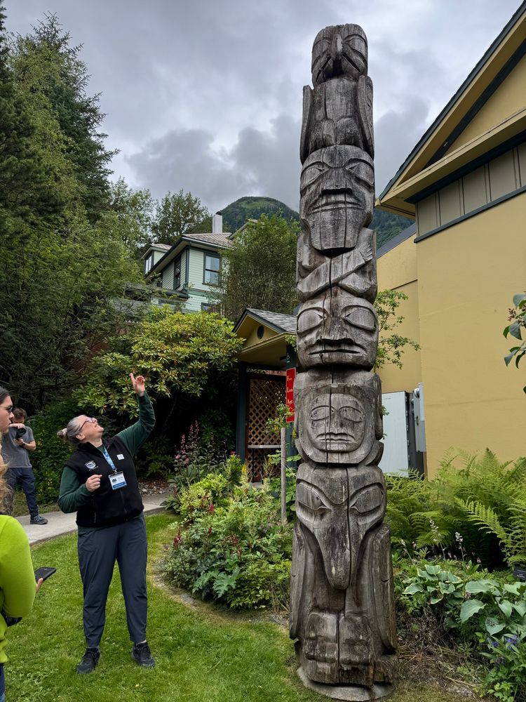 The Juneau- Douglas city Museum, Director, gestures at the totem pole named harnessing the atom