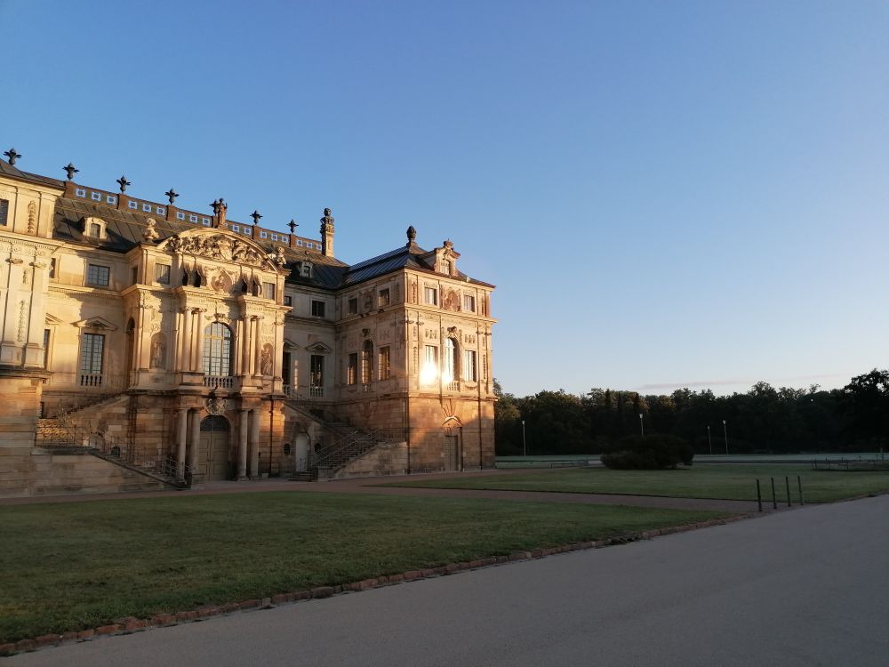 Palais im Großen Garten. Die aufgehende Sonne spiegelt sich in einem der Fenster. 