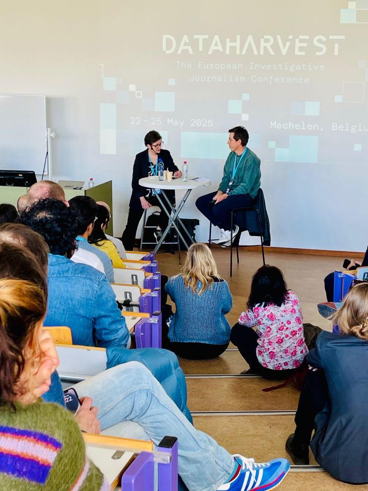Investigative journalist Laurent Richard, is being interviewed by Ulla Sätereie, with a big audience, and the Dataharvest logo projected on the background.