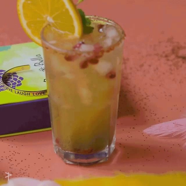 a drink in a glass next to a box that says laugh love