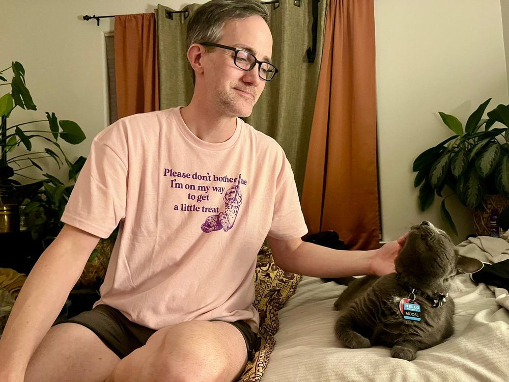 A guy petting an appreciative cat 
