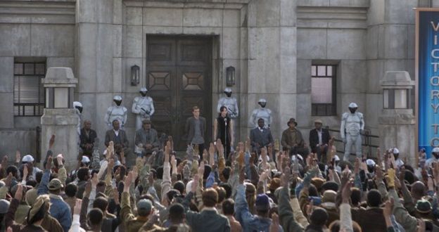 A crowd making the three finger salute from "The Hunger Games"