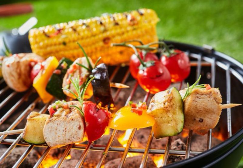 Grill mit glühender Kohle und Gemüse auf dem Rost