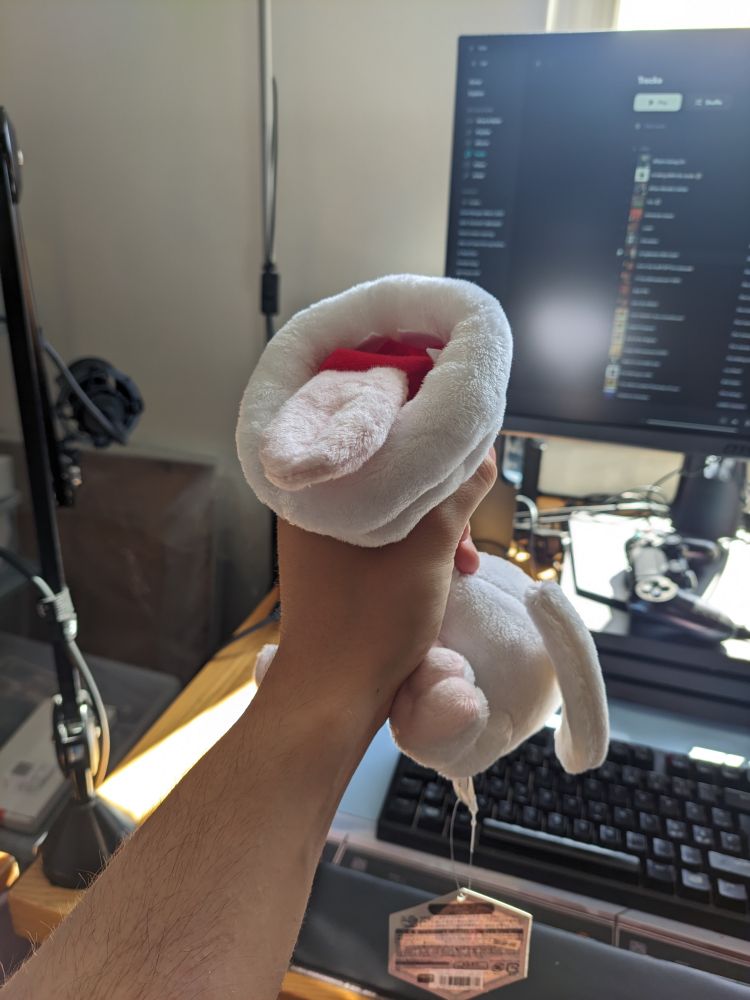 A freaky ass plush of Khezu from monster hunter being strangled