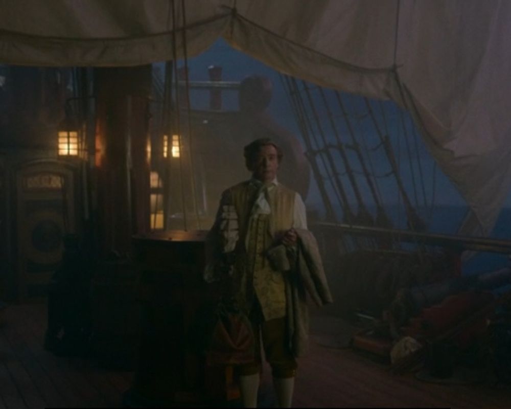 Stede from OFMD on the deck of the Rwvenge with his bags