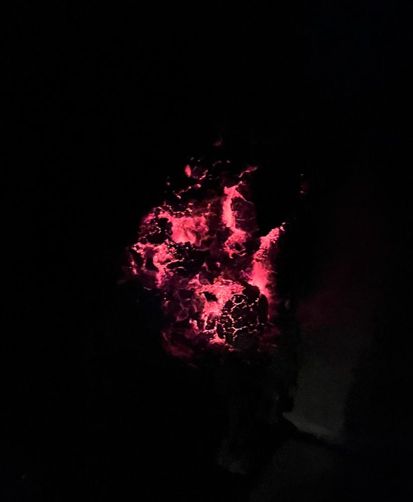 Glowing red embers as a fire cools down.