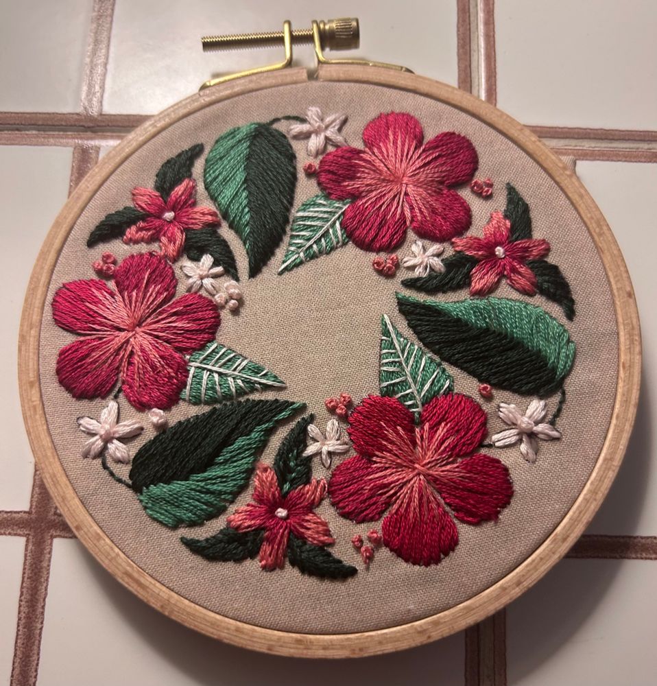 Small Hand embroidered flowers in pink, red and white with dark green and light green leaves. 