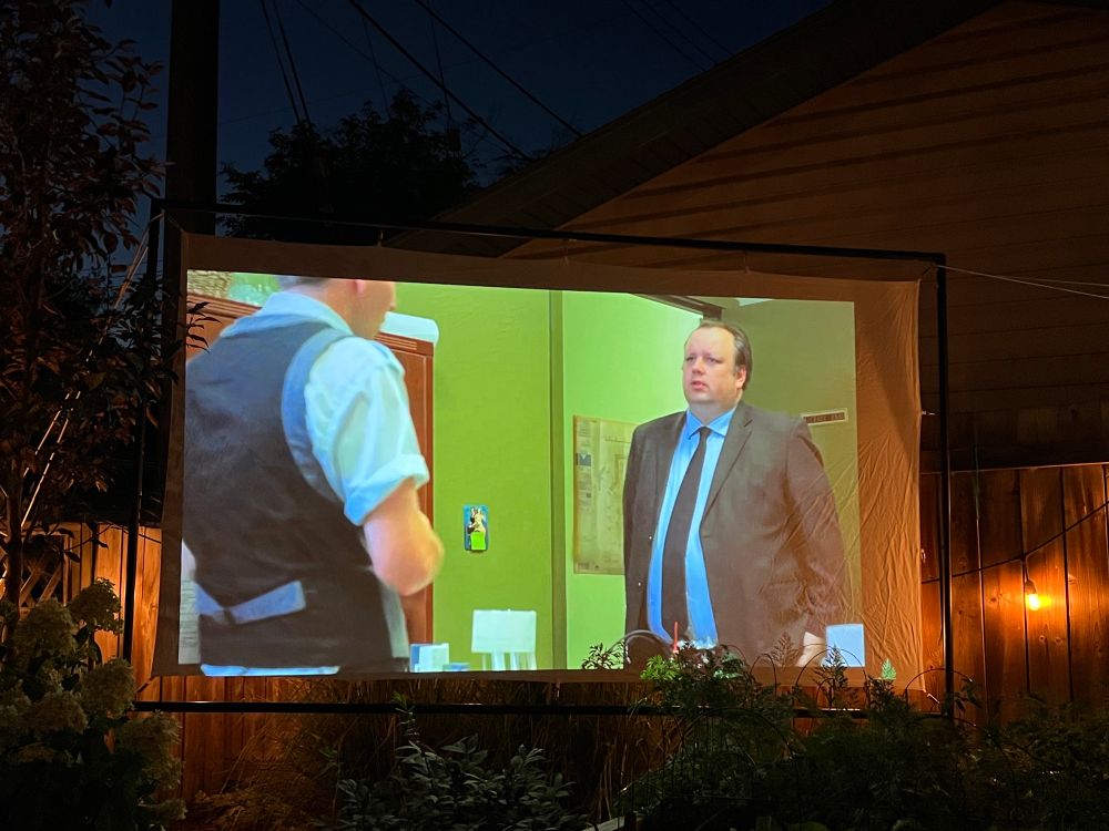 Photo of a movie screen in Jen’s backyard with a scene from The Bike Heist.