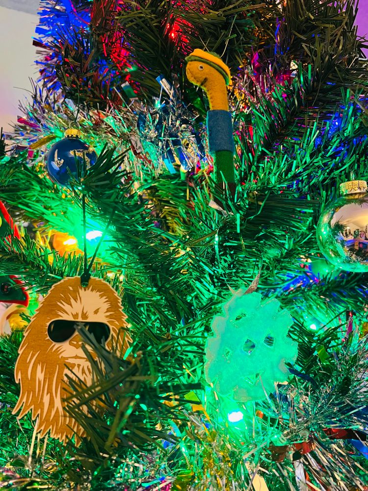 Photo of a Chewbacca and lowly worm ornament on a tree.