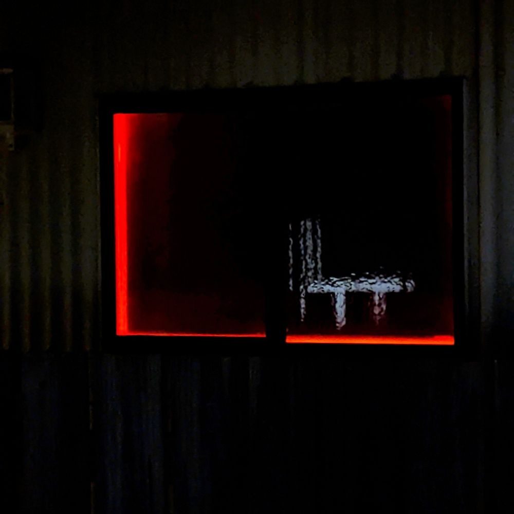 Red light escaping around window blinds.