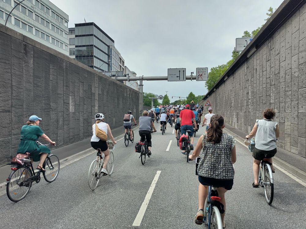 Viele Fahrradfahrer:innen fahren aus dem Tunnel heraus.