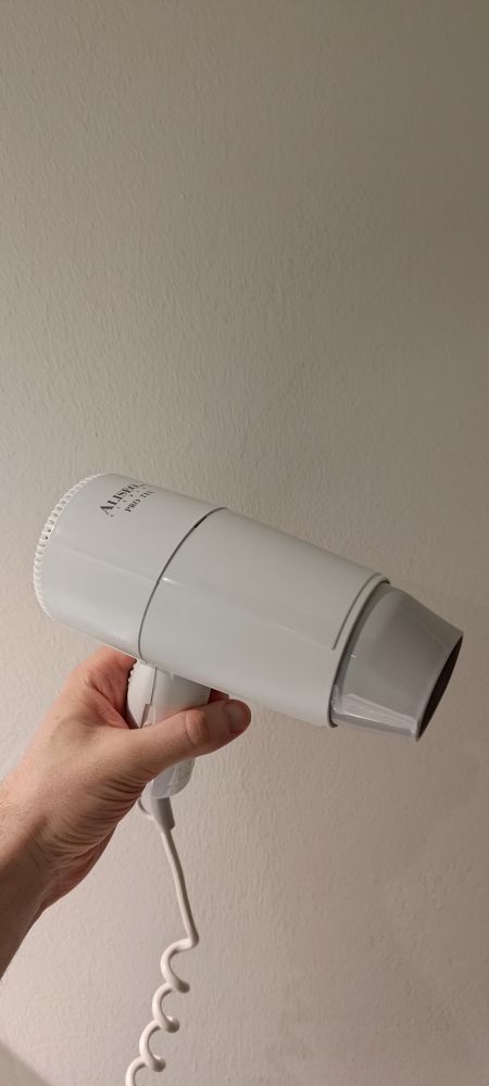 A white hair dryer. Text on it indicates that brand name is "Aliseo" and that it is a product of Germany.