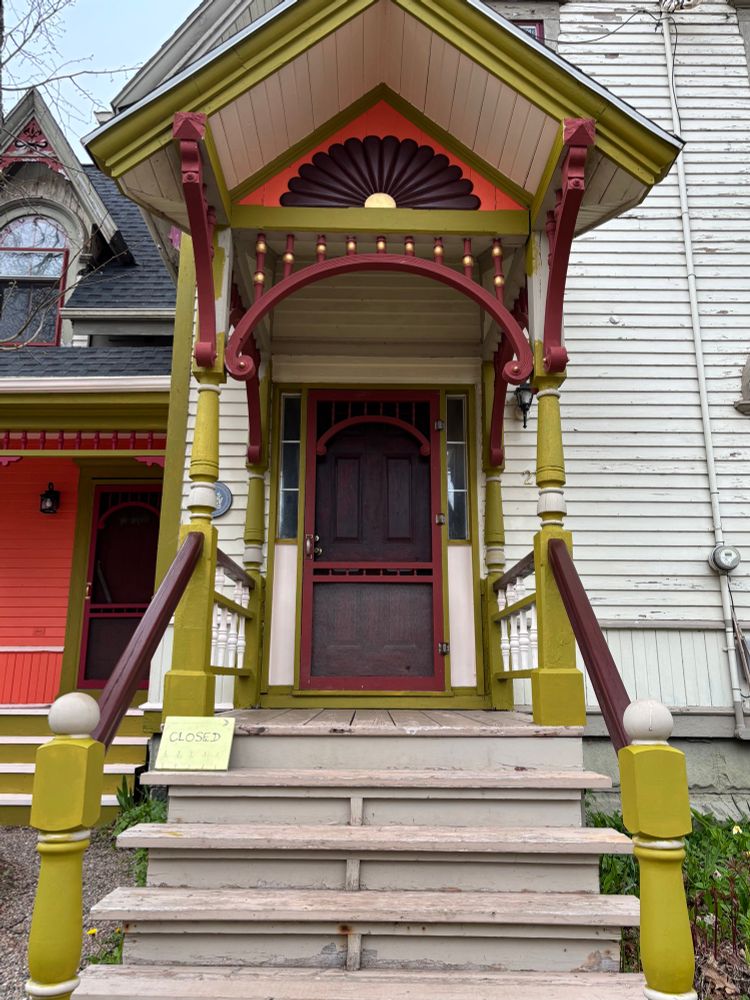 Multi coloured entrance to a Victorian era home. It is in the process of being painted with 6 different colours 