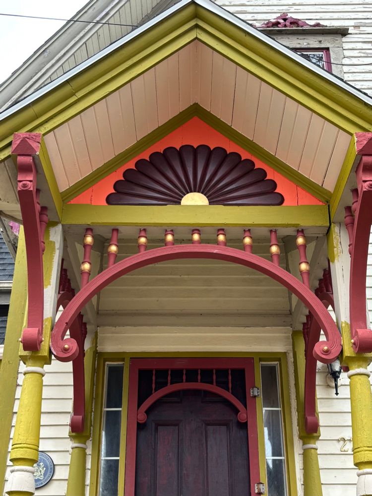 Decorative woodwork on the entrance of a Victorian house that is being painted 