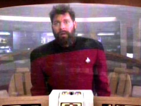 A bearded man with unkempt hair and a stressed expression, an alternate timeline Commander Will Riker, on the Enterprise bridge. 