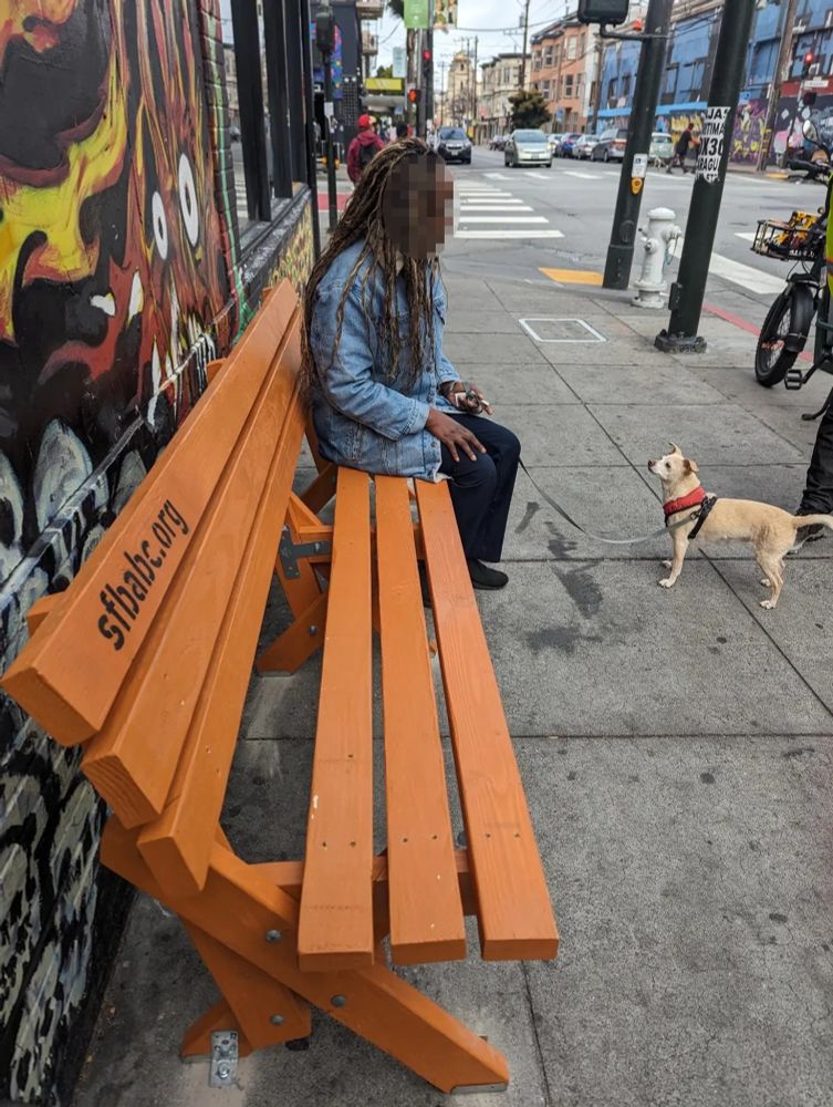 somebody sitting on a bench at 18th/Mission