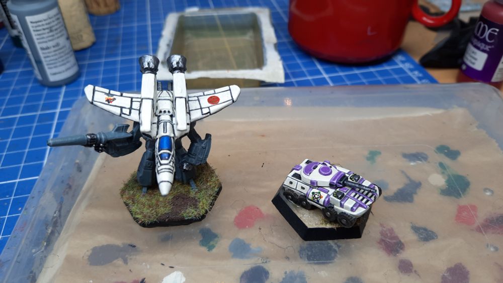 A Battletech PHawk LAM and a Chevalier Tank standing on a closed wet pallette.