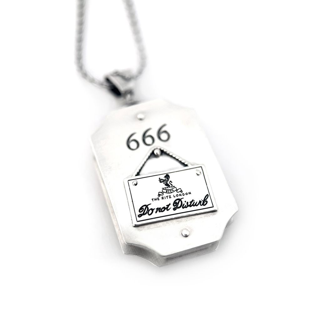 The pendant swivels on the bail so it is reversible without removing it. The back is engraved with "666" as though it is a hotel room number, and beneath that is a small replica of the "Do not disturb" sign from the Ritz hotel.
