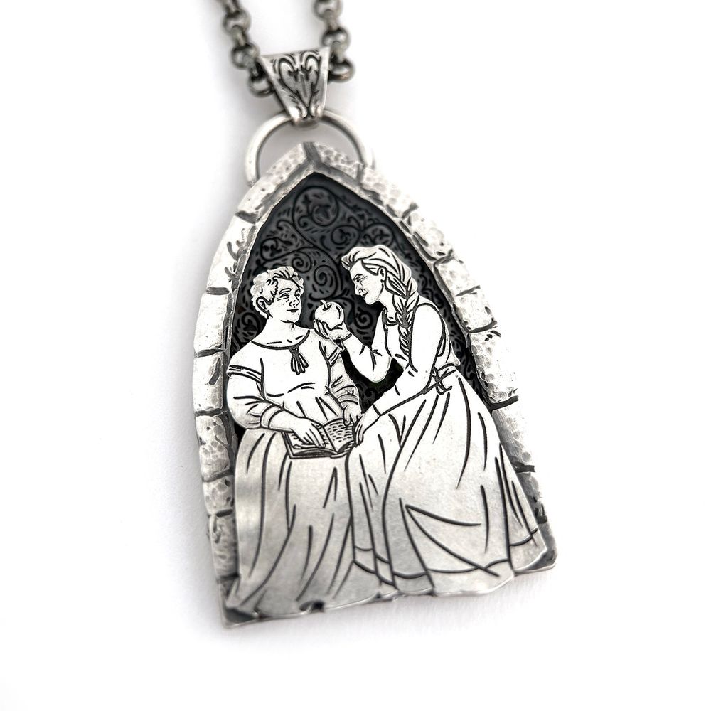 A sterling silver pendant with female-presenting Aziraphale and Crowley in medieval dress, sitting in a carved stone gothic arch window. Aziraphale has a book open on her lap; Crowley is leaning in and offering her an apple. The backplate has a vine pattern and is deeply oxidized. The pendant hangs from a triangular bail that continues the vine motif in the shape of a heart.