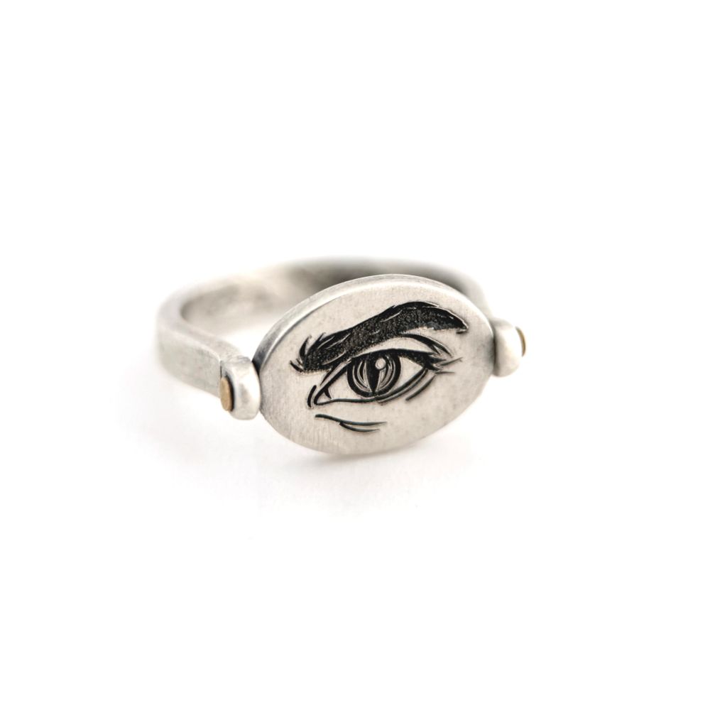 A silver ring with my sketch of Crowley’s eye engraved onto one side of a swiveling disc riveted with brass.